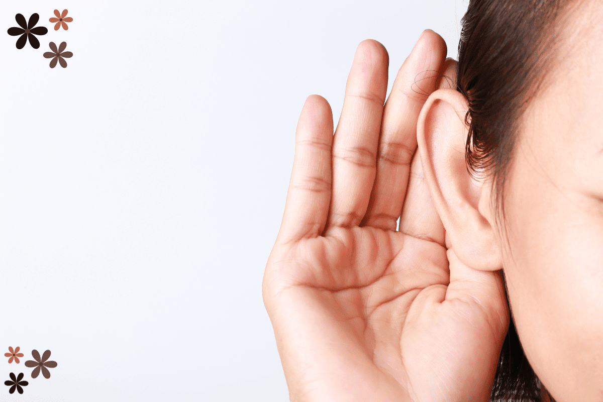 A woman cupping her ear as though she is listening