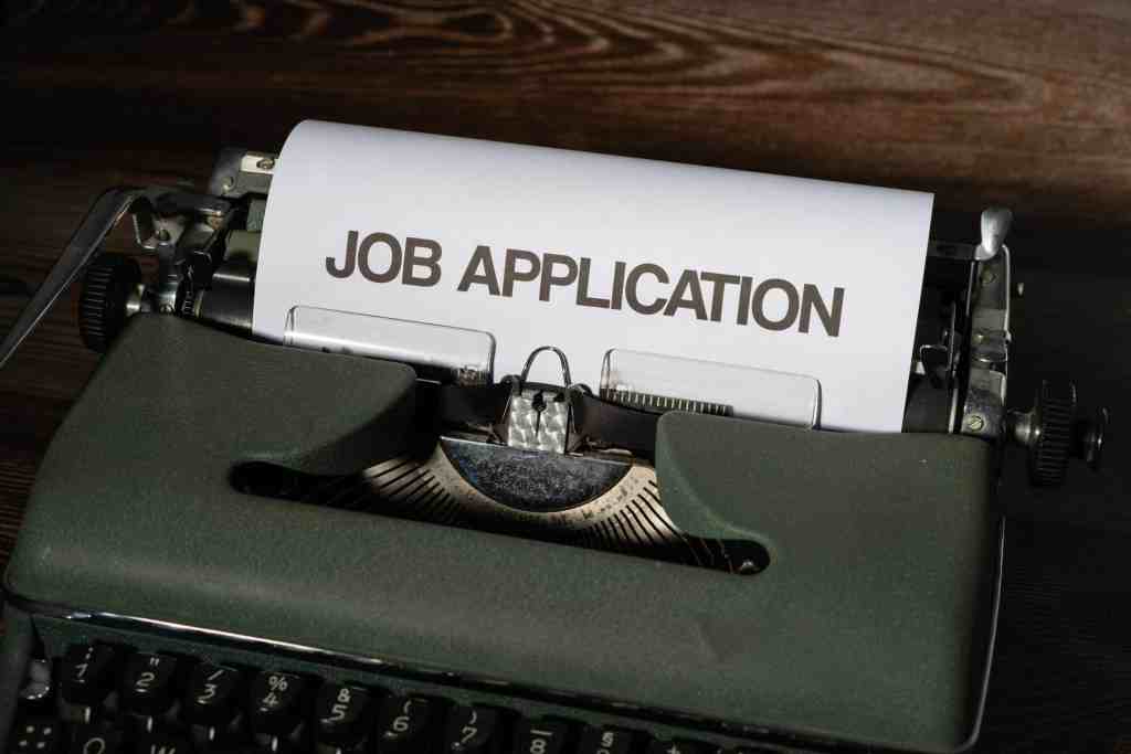 A typewriter printing out a page that reads job application