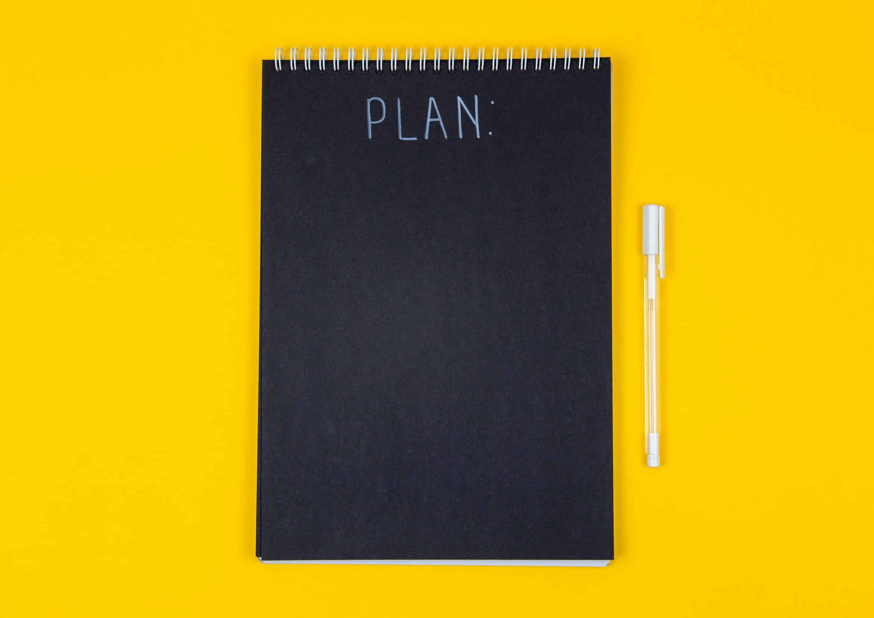 volodymyr-hryshchenko-x_OKGbxB3fA-unsplash A black notebook with the words plan on it