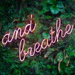 A lit up sign that reads "and breathe"