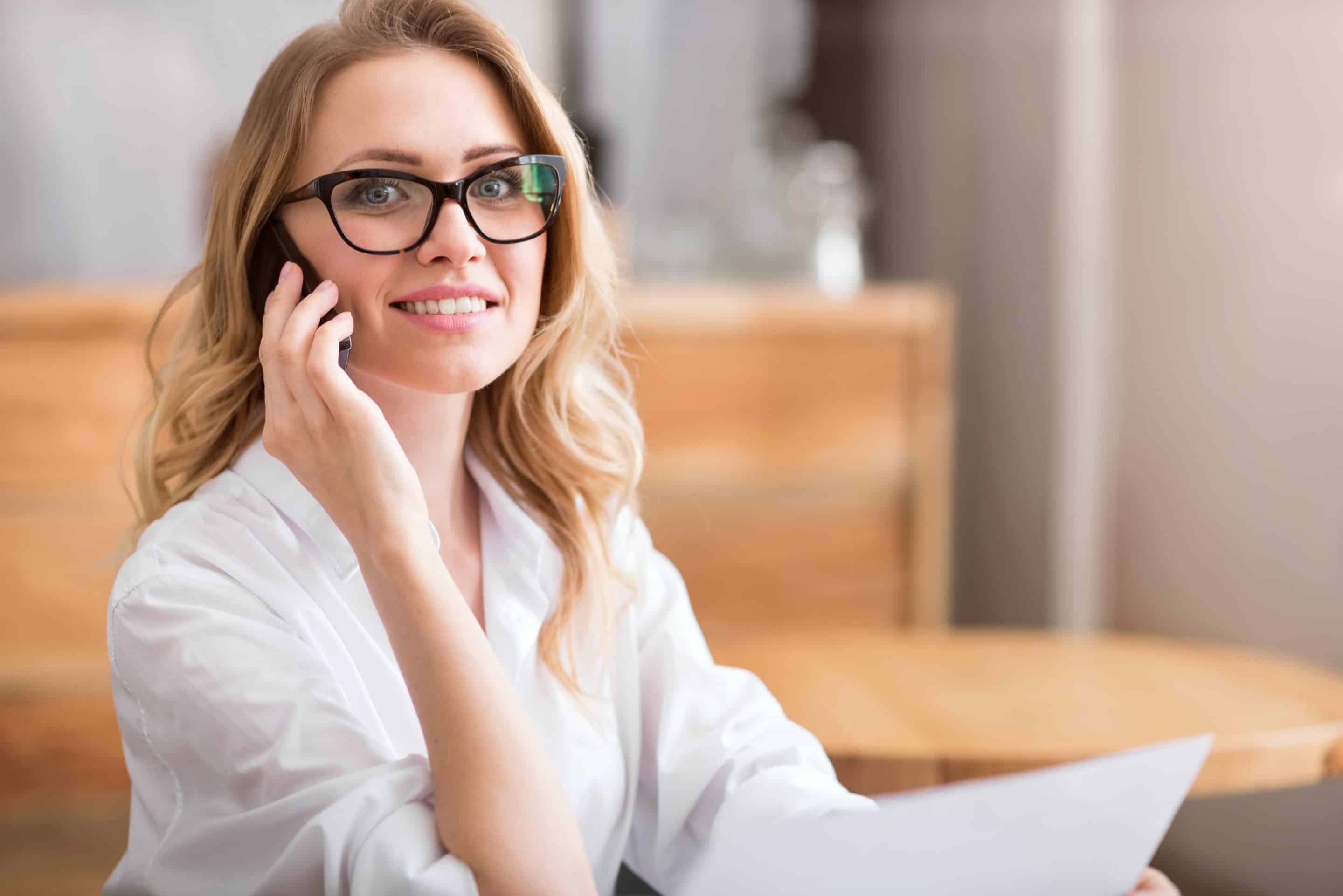 manager A woman with glasses smiling while she talks on the phone