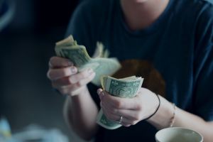 A person with a lot of cash in their hand appearing to count it