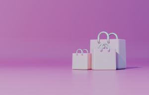 Three light pink shopping bags against a pink background