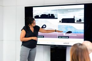 A woman presenting on a big screen