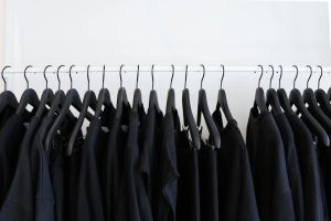 All black clothes hanging in a closet