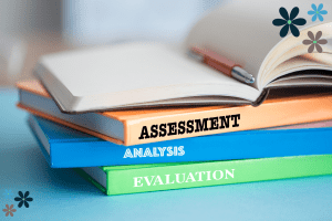 A stack of books with one book that says "assessment", another with "analysis" and a final book with "evaluation"