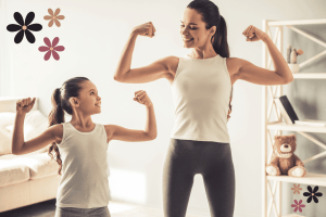 Mom and daughter in matching white tank tops flexing their muscles