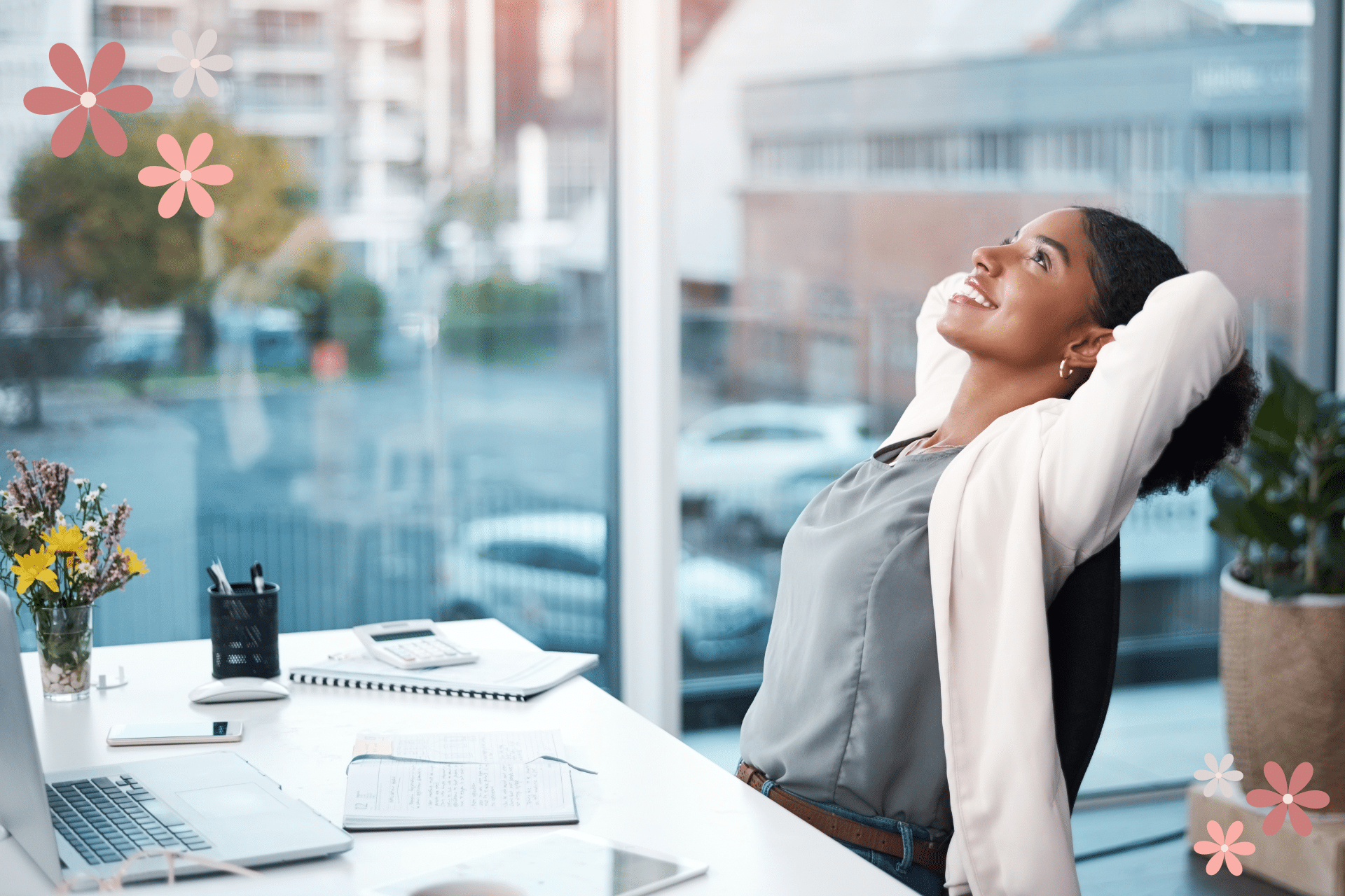 Woman sitting at her desk leaning back in her chair smiling