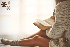 Woman sitting with her legs up while she is reading a book