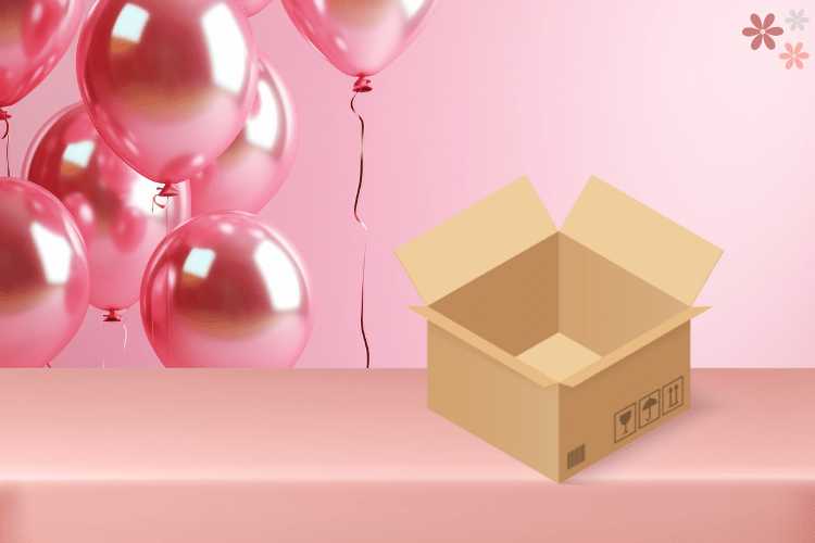 An empty corrugated box sitting on a pink table in front of pink balloons