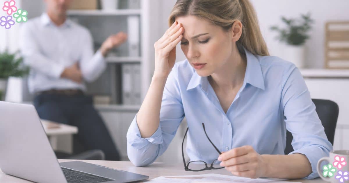 Woman feeling stressed and overwhelmed at work while reviewing finances at her desk